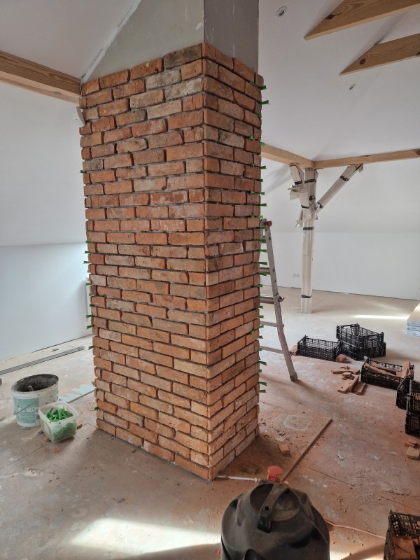 zdjęcie komina obłożonego płytkami imitującymi cegłę