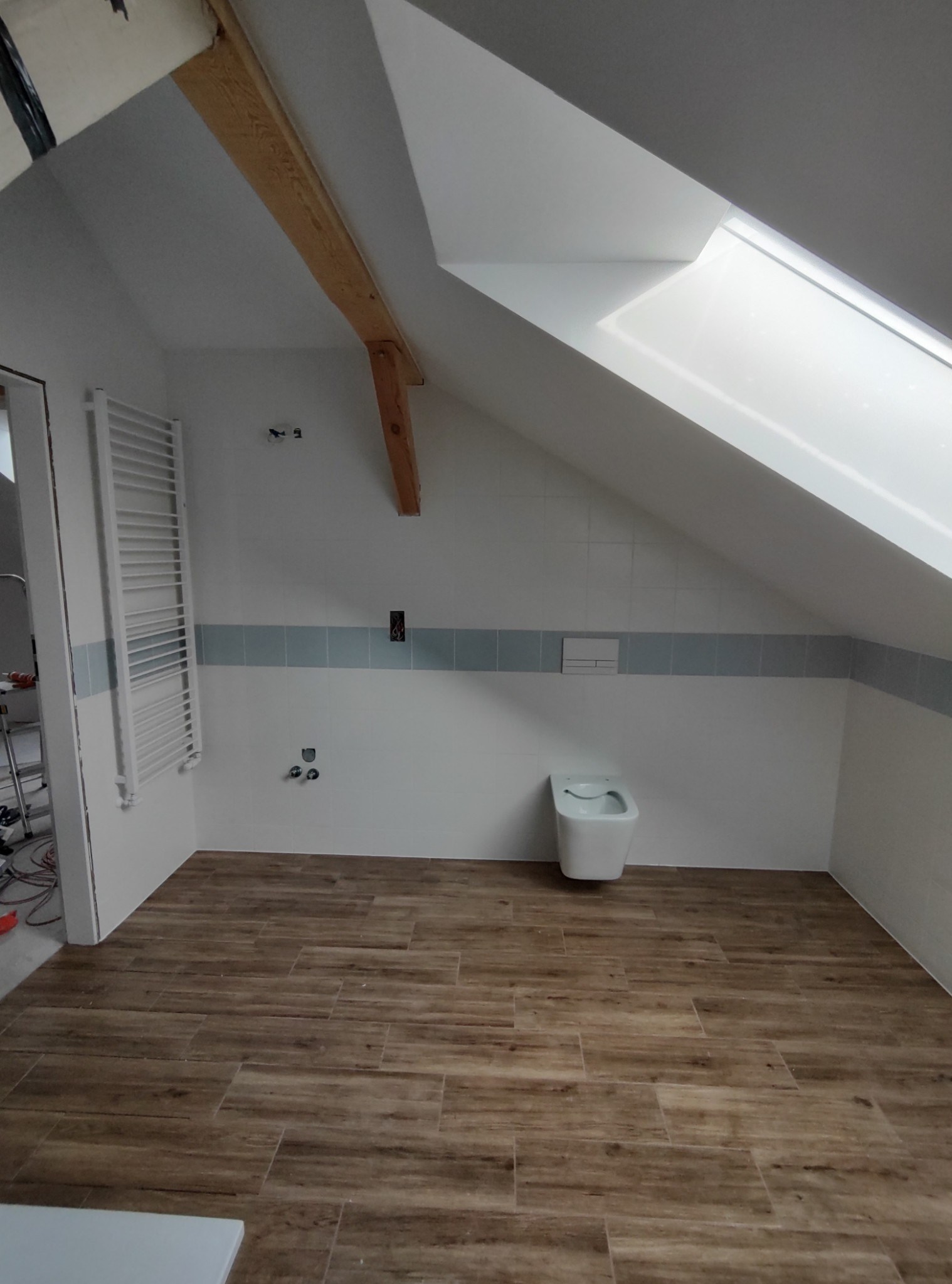 łazienka z terakotą o wzorze drewna i podwieszaną muszlą klozetową