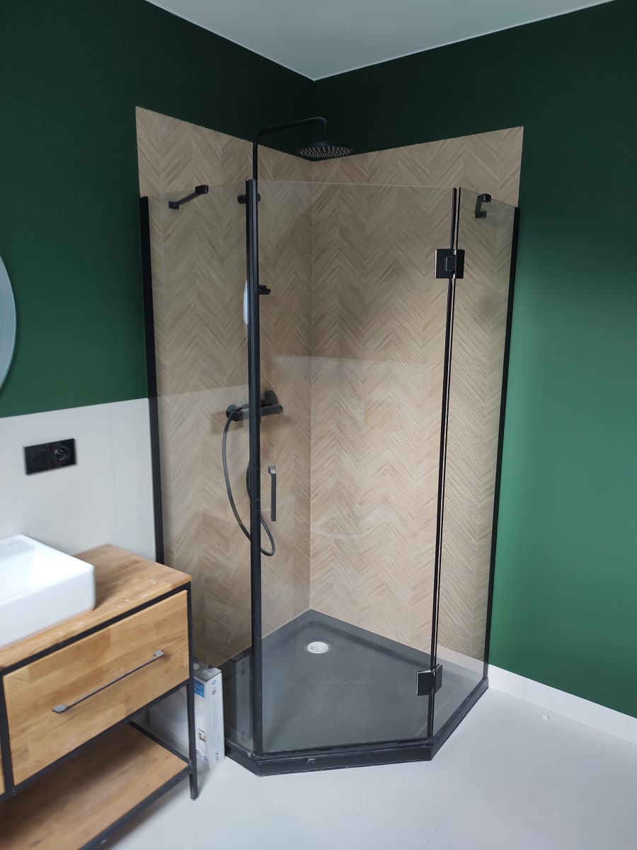 Zdjęcie szklanej kabiny prysznicowej na tle zielonej ściany