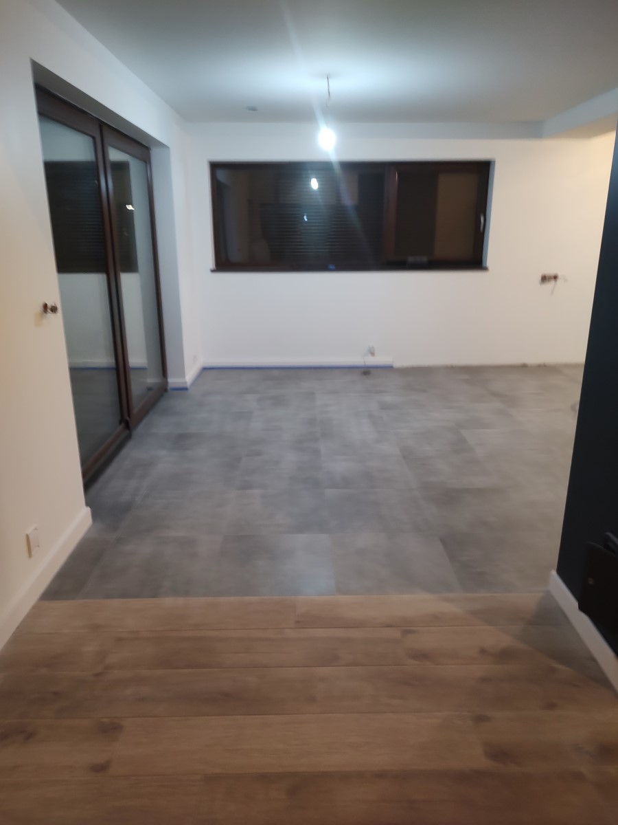 salon z dużym oknem tarasowym, terakotą o kamiennym wzorze