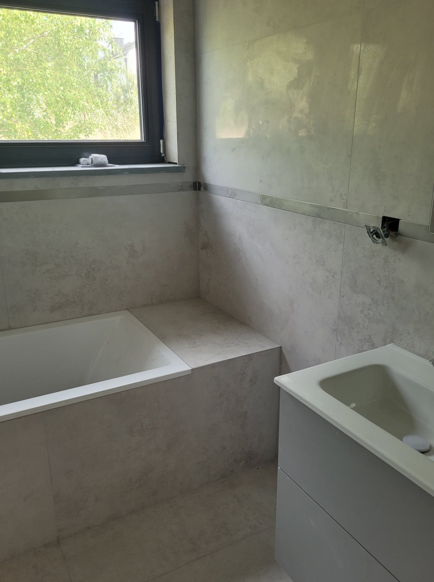 łazienka z oknem, wanną i umywalką nablatową